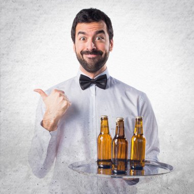 Garson bira şişeleri başparmak ile tepsi ile