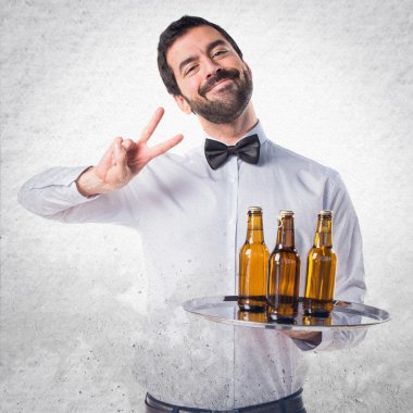 Garson bira şişeleri zafer jest yapıyor tepsi ile