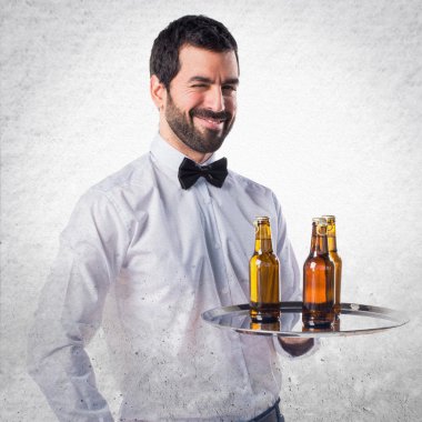 Garson tepsi göz kırpıyor üzerinde bira şişeleri ile