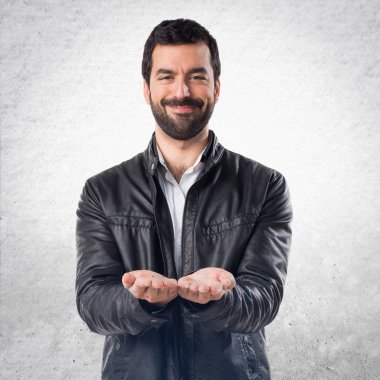 Adam bir şey tutan deri ceket ile