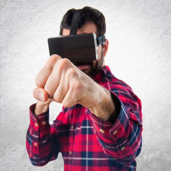 Hombre usando gafas VR dando un puñetazo —  Fotos de Stock