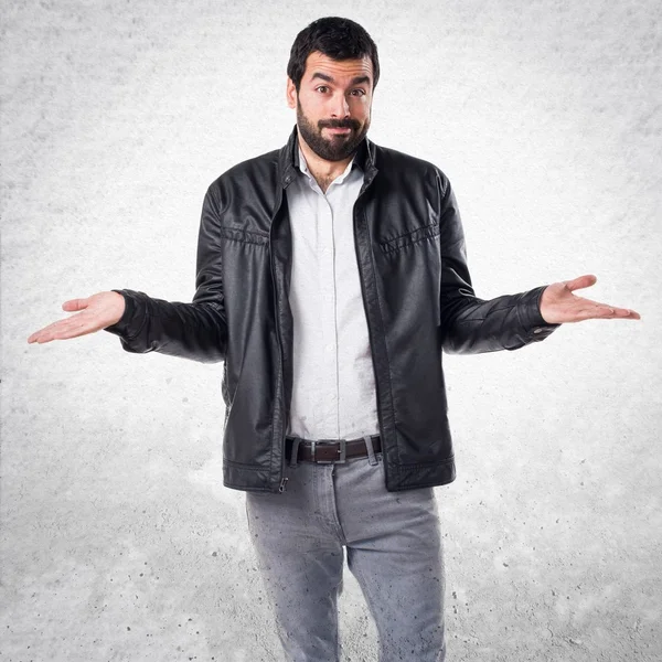 Hombre con chaqueta de cuero haciendo gesto sin importancia — Foto de Stock