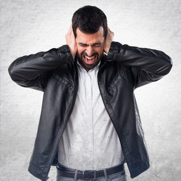 Man with leather jacket covering his ears — Stock Photo, Image