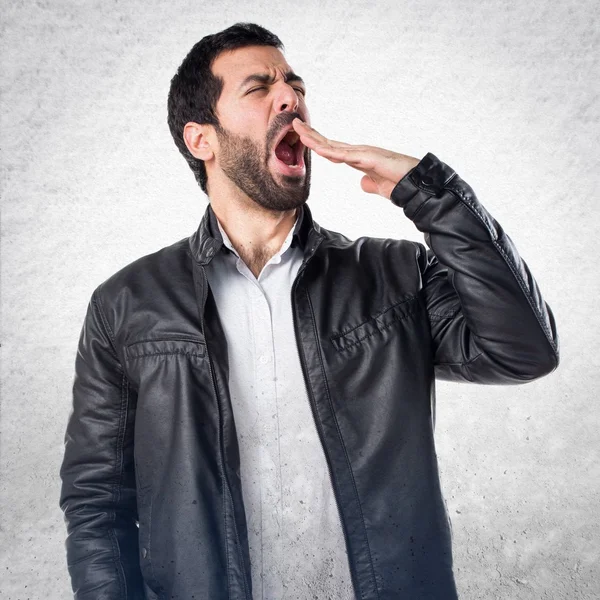 Человек в кожаной куртке зевает — стоковое фото