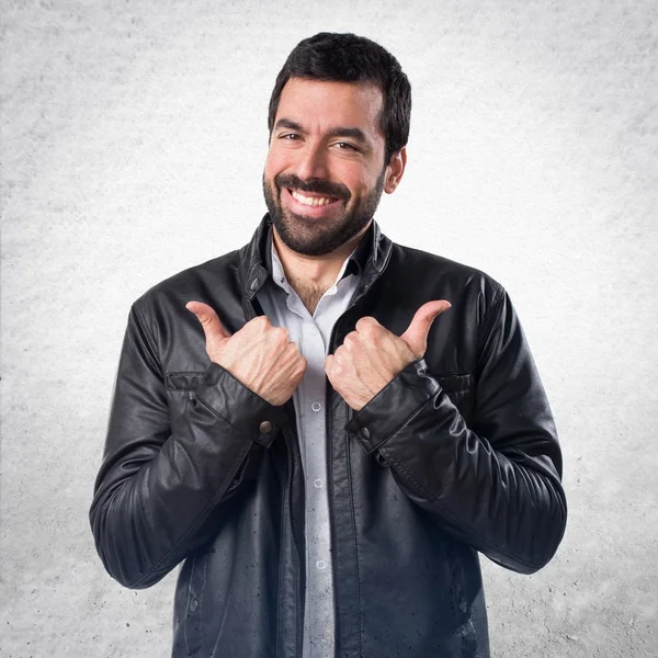 Deri ceket başparmak ile olan adam