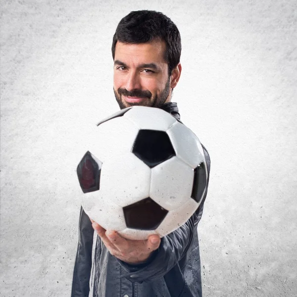 Uomo con giacca di pelle con un pallone da calcio — Foto Stock