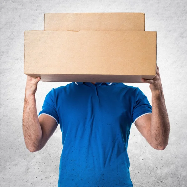 Entrega homem escondido atrás de suas caixas — Fotografia de Stock