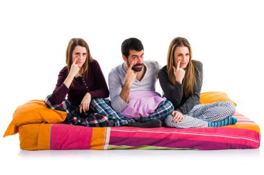 Üç arkadaş bir yatakta bir şeyler gösteriyor