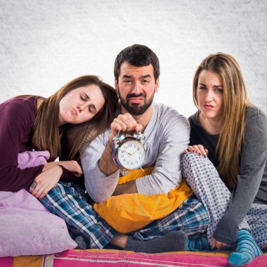 Vintage saat tutan bir yatakta üç arkadaş