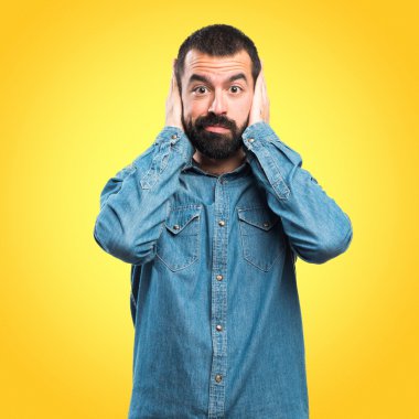 Adam kulaklarını kapatıyor.