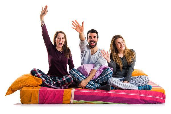 Three friends on a bed saluting