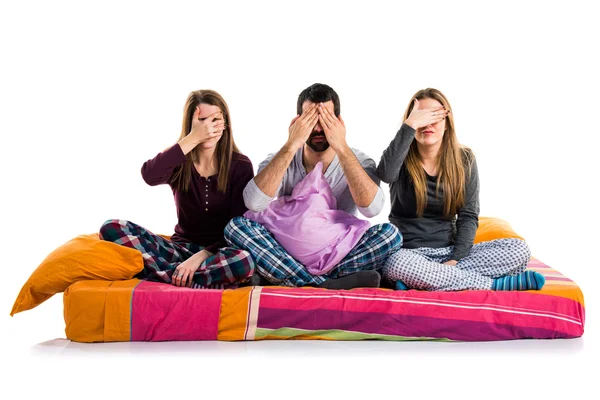 Tři přátelé na lůžku pokrývající jejich oči — Stock fotografie