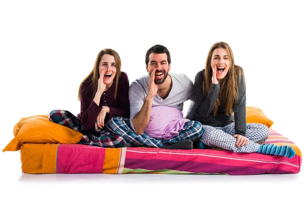 Tre amici su un letto che gridano — Foto Stock