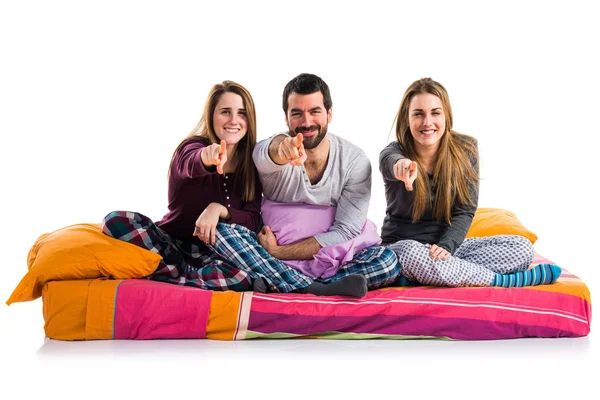 Tres amigos en una cama apuntando al frente — Foto de Stock