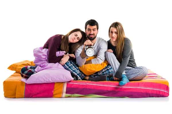 Трое друзей на кровати держат винтажные часы — стоковое фото