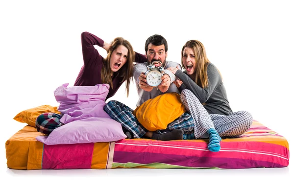 Трое друзей на кровати держат винтажные часы — стоковое фото