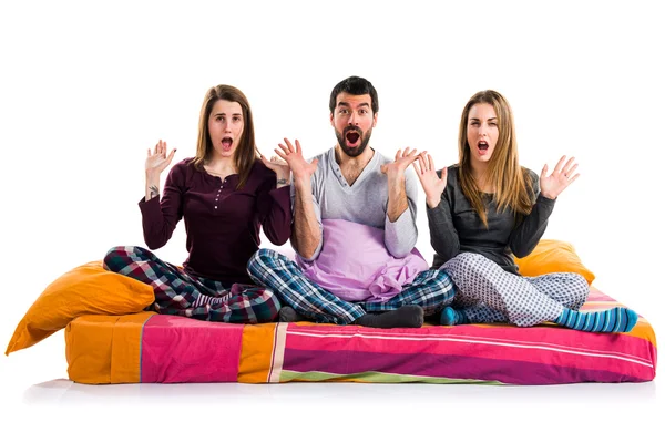 Three friends on a bed doing surprise gesture Royalty Free Stock Images