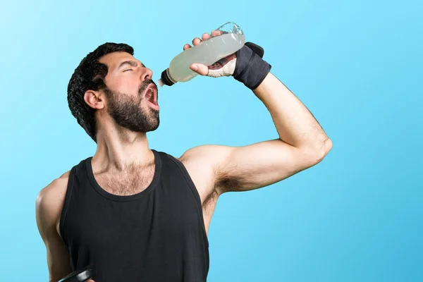 Sportman che fa sollevamento pesi soda acqua potabile — Foto Stock