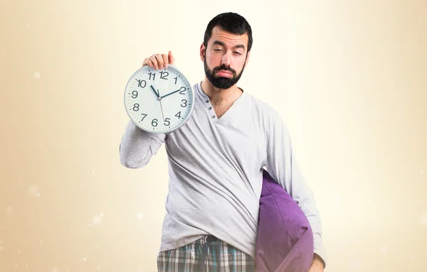 Человек в пижаме держит часы — стоковое фото