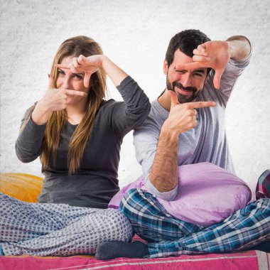 Onun parmaklarıyla odaklanan bir yatakta üç arkadaş