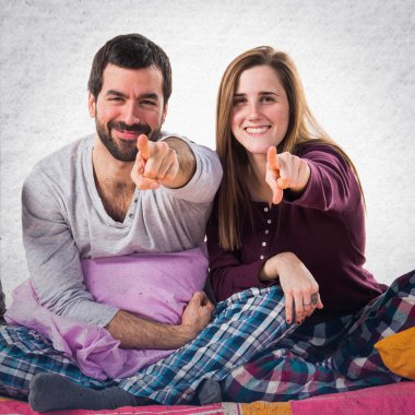 Öne doğru işaret eden bir yatakta üç arkadaş