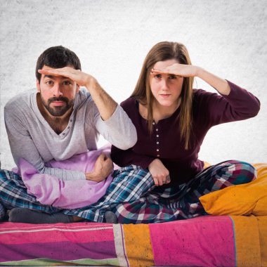 Üç arkadaş bir yatakta bir şeyler gösteriyor