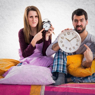 Vintage saat tutan bir yatakta üç arkadaş