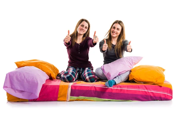Friends on bed with thumb up — Stock Photo, Image