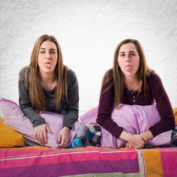 Sisters on bed doing a joke — Stock Photo, Image
