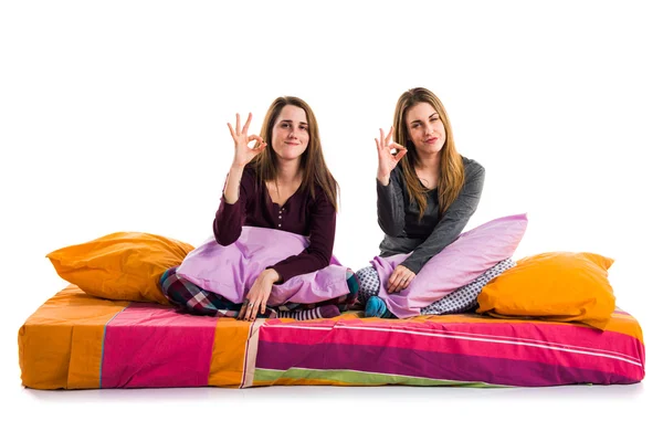 Hermanas en la cama haciendo señal OK —  Fotos de Stock