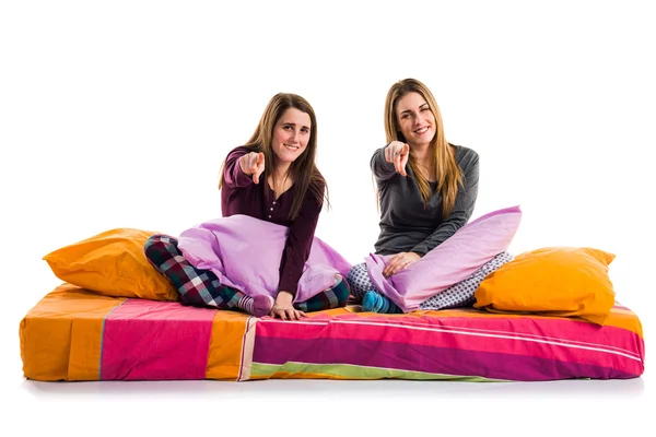 Hermanas en la cama apuntando al frente — Foto de Stock