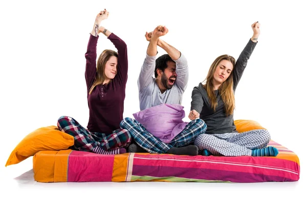 Tres amigos en una cama bostezando —  Fotos de Stock