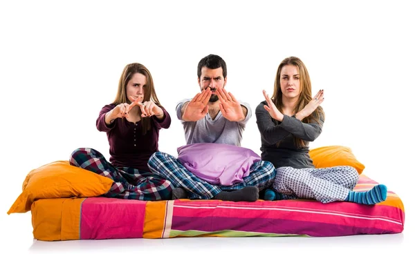 Dur işareti yapmak bir yatakta üç arkadaş