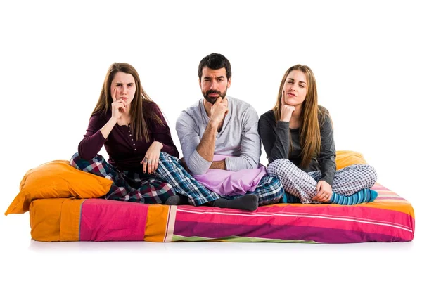 Tre amici su un letto che pensano — Foto Stock