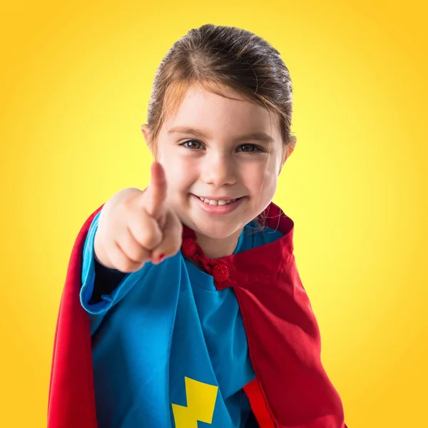 Flicka klädd som superhjälte pekar på framsidan — Stockfoto