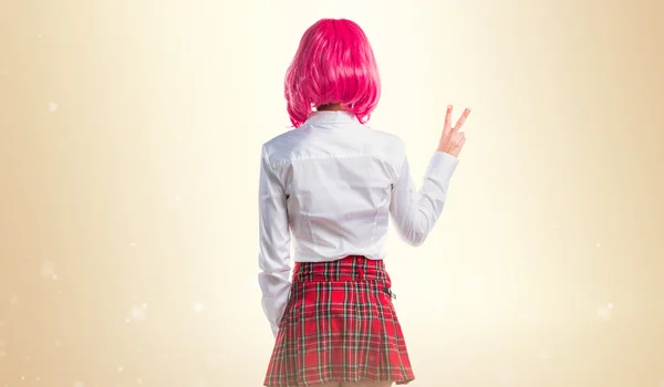 Menina com cabelo rosa fazendo gesto de vitória — Fotografia de Stock