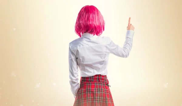 Menina com cabelo rosa apontando para trás — Fotografia de Stock