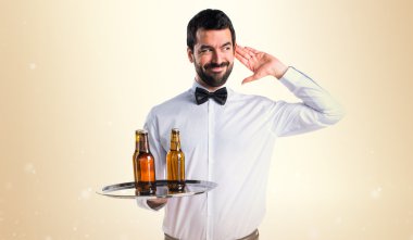 Bira şişe bir şey dinlerken tepsi ile garson