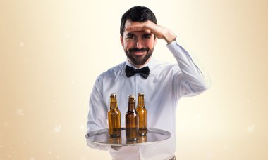 Bira şişe bir şey gösterilen tepsi ile garson