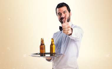 Garson bira şişeleri başparmak ile tepsi ile