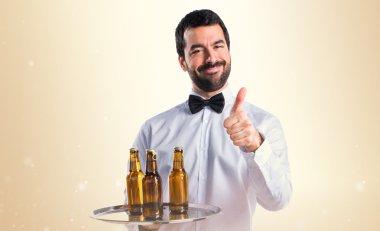 Garson bira şişeleri başparmak ile tepsi ile