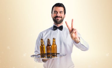 Garson bira şişeleri zafer jest yapıyor tepsi ile