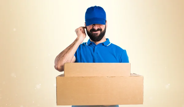 Delivery man covering his ears — Stock Photo, Image