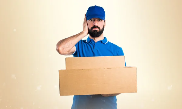 Delivery man covering his ears — Stock Photo, Image