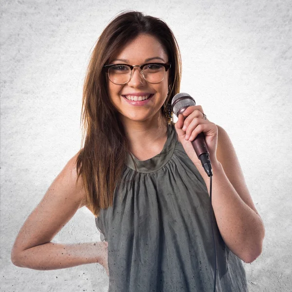 Mladá dívka zpívající s mikrofonem — Stock fotografie
