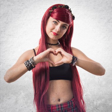 Genç Kızıl saçlı kız elleri ile bir kalp yapma