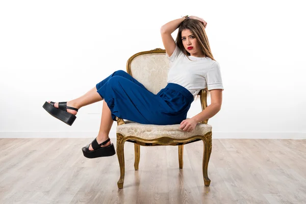 Красивая девушка на винтажном диване — стоковое фото