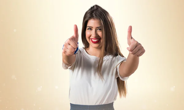 Chica joven con el pulgar hacia arriba — Foto de Stock