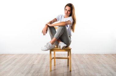 Sarışın kız sandalye üzerinde poz