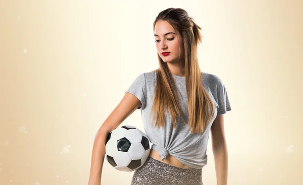 Mulher jogador segurando uma bola de futebol — Fotografia de Stock